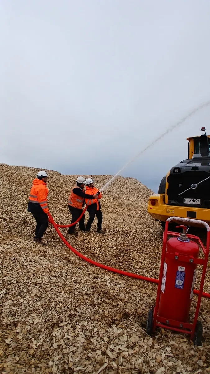 Brigada lanzando agua sobre acopio de astillas con el carro contra incendios Modelo Mejorado